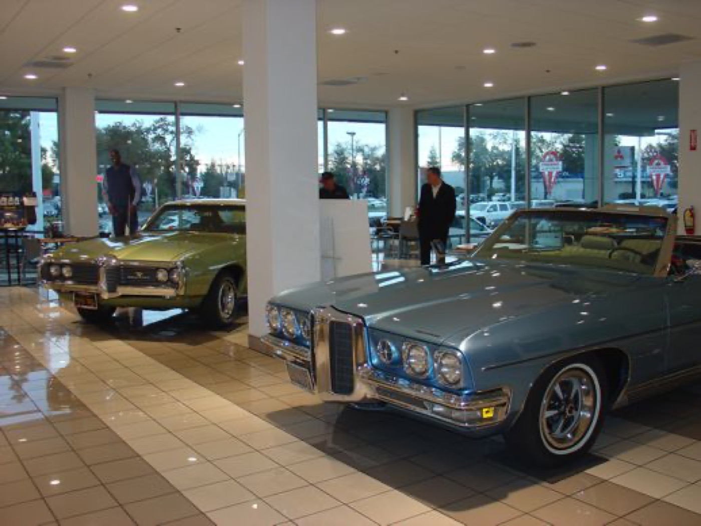 Blue and green Pontiacs gracing the showroom