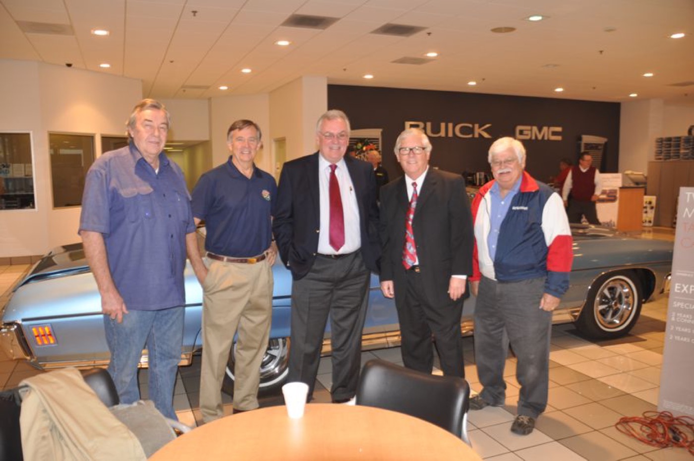 Club gentlemen gathered before vintage convertible