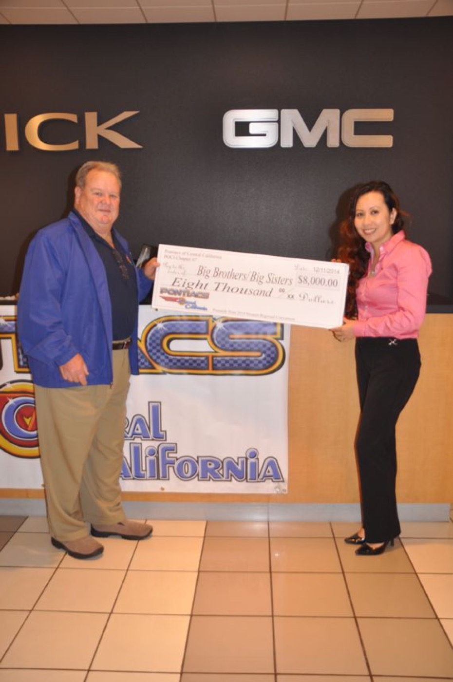 Big check handoff at the dealership showroom