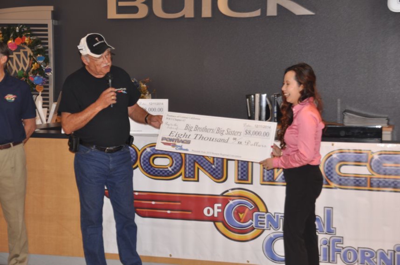 Club presents oversized donation check at banner