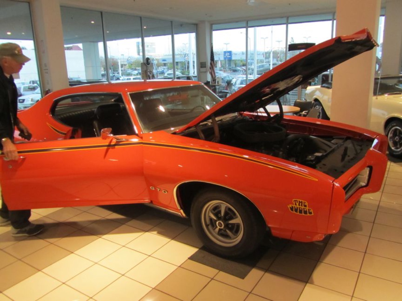 Member opening door of red GTO Judge