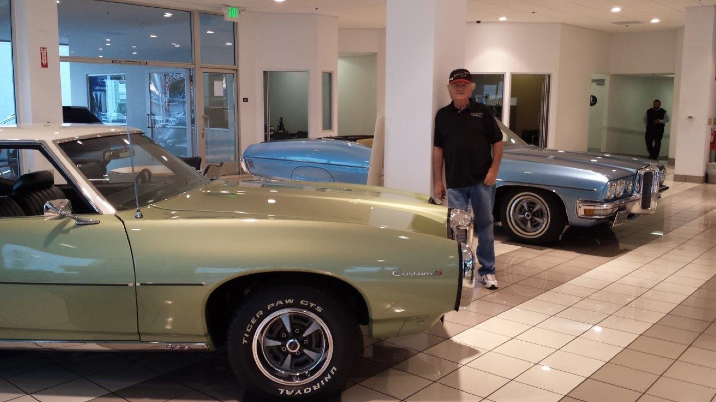 Member poses among green and blue classics